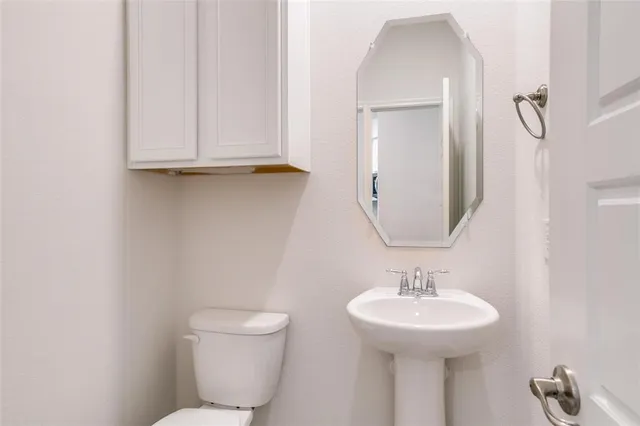 a bathroom with a toilet sink and mirror