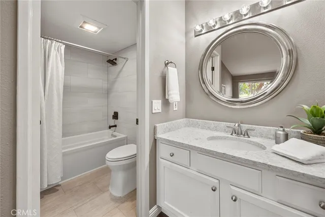 a bathroom with a granite countertop toilet sink and a mirror