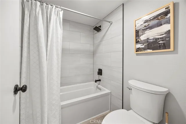 a white toilet sitting next to a bath tub