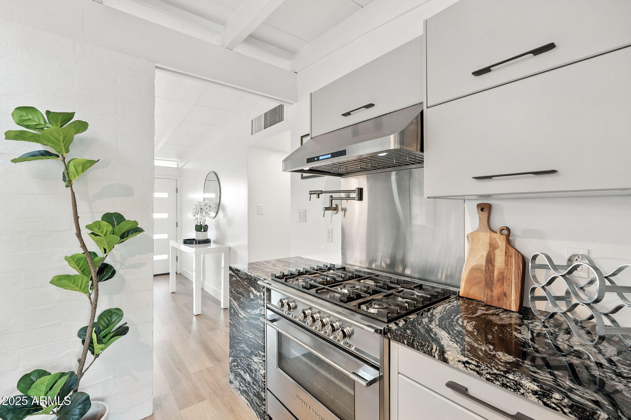 5809 North 10th Place Phoenix, AZ 85014 - Photo 17 of 81 a kitchen with granite countertop stainless steel appliances stove a sink and white cabinets