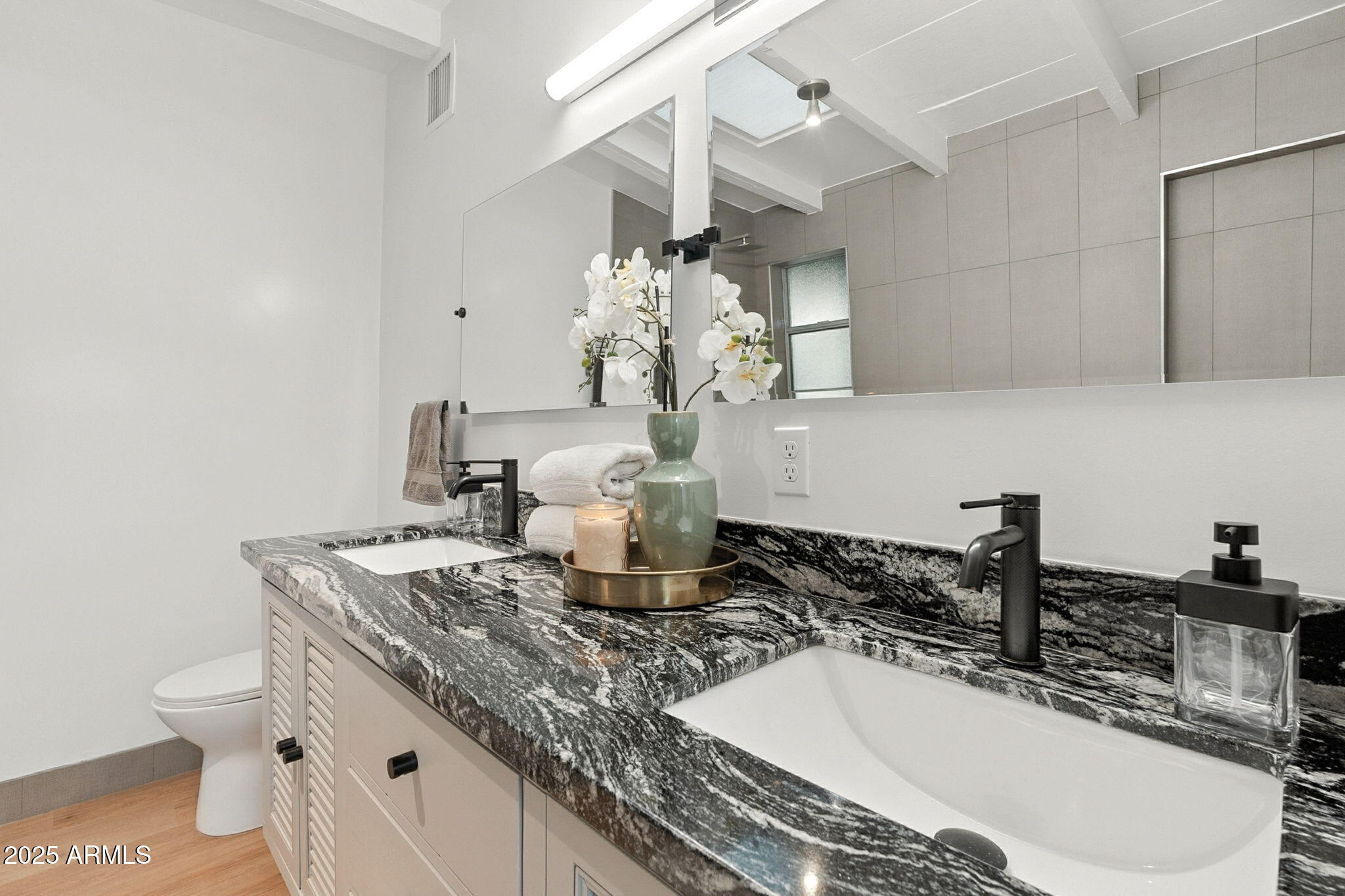 5809 North 10th Place Phoenix, AZ 85014 - Photo 26 of 81 a bathroom with a granite countertop sink a toilet and a mirror