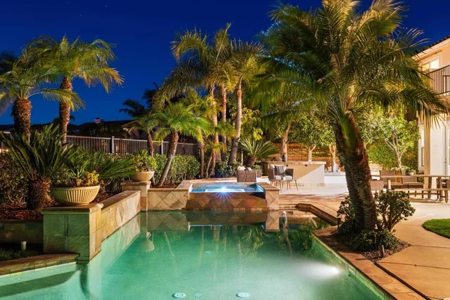 a view of a patio with couches and chairs under an umbrella