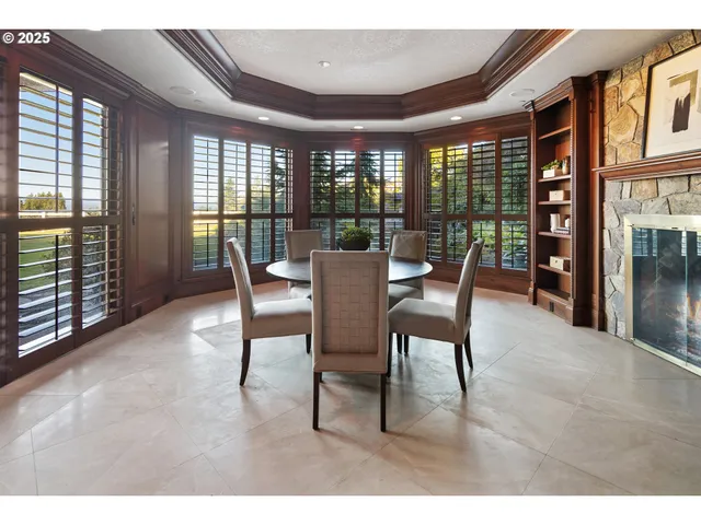 a dining room with furniture large windows and wooden floor