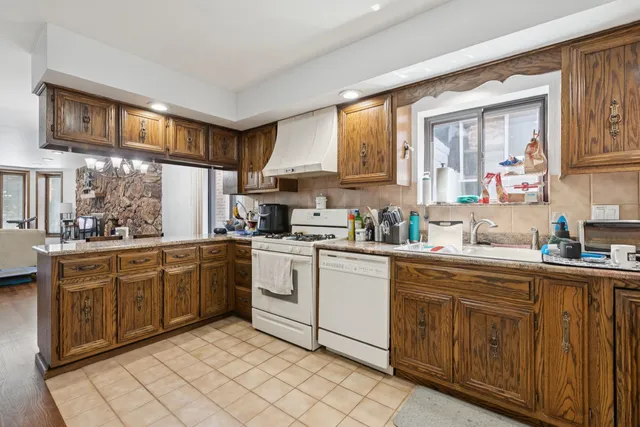 a kitchen with cabinets appliances a sink and a window
