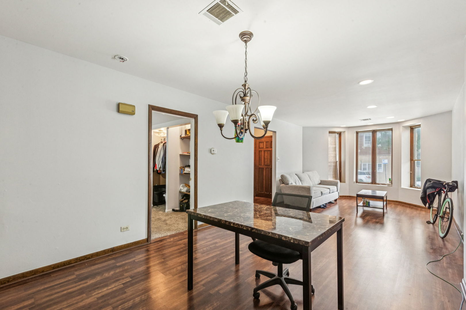3234 South Princeton Avenue Chicago, IL 60616 - Photo 32 of 56 a living room with dining table and wooden floor