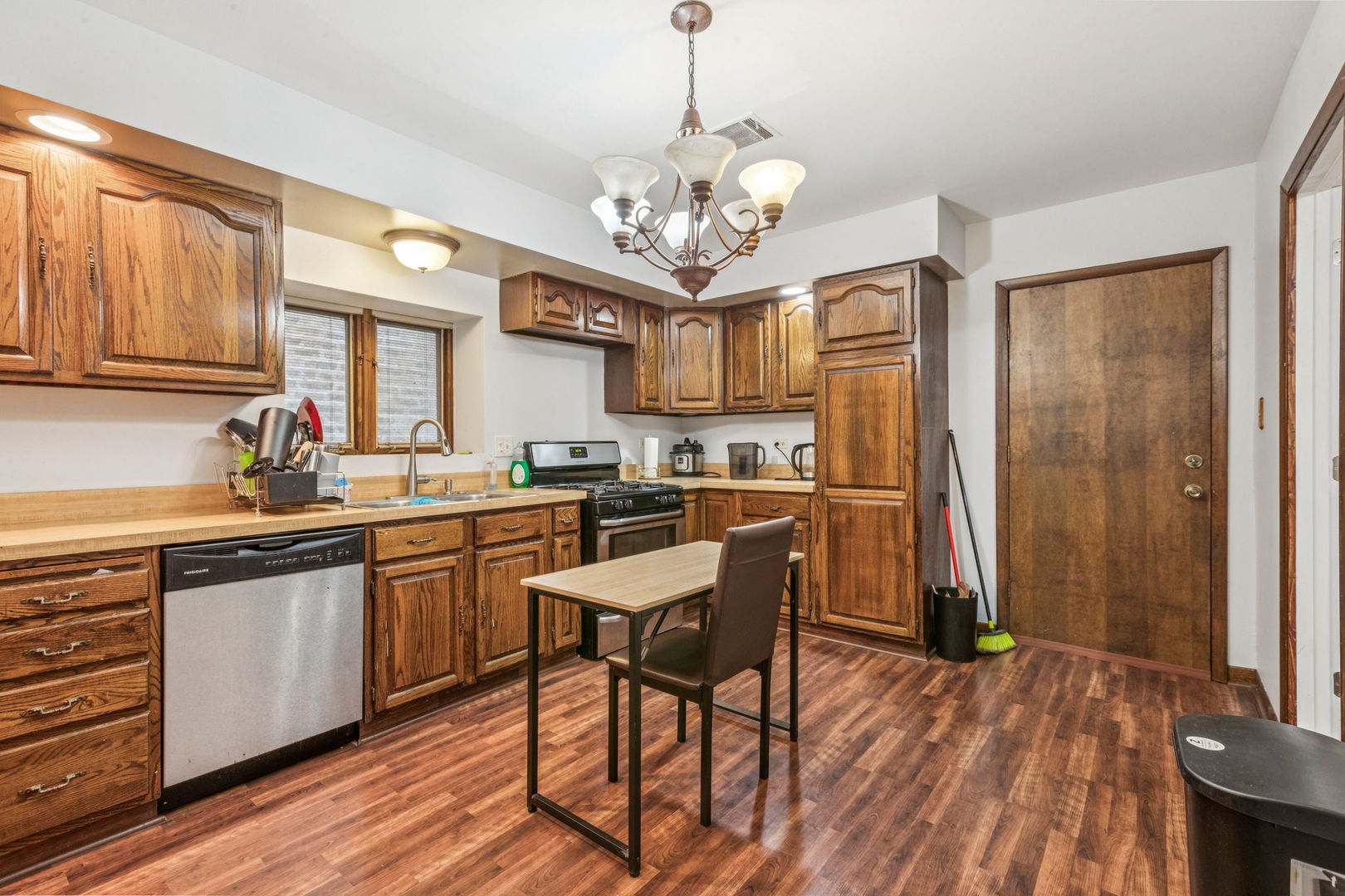 3234 South Princeton Avenue Chicago, IL 60616 - Photo 36 of 56 a kitchen with stainless steel appliances granite countertop a refrigerator a sink dishwasher a dining table and chairs with wooden floor