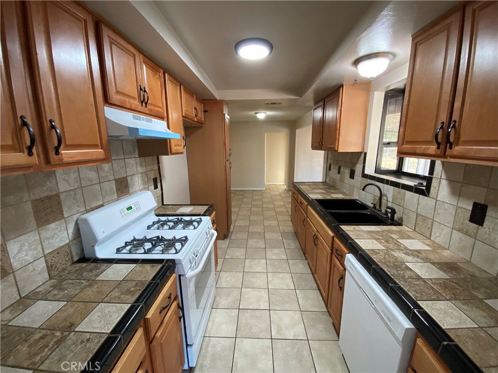 18746 Rock Springs Road Hesperia, CA 92345 - Photo 5 of 21 a kitchen with stainless steel appliances granite countertop a stove a sink and a microwave