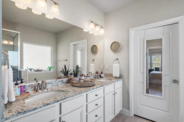 a bathroom with double vanity sinks and a mirror