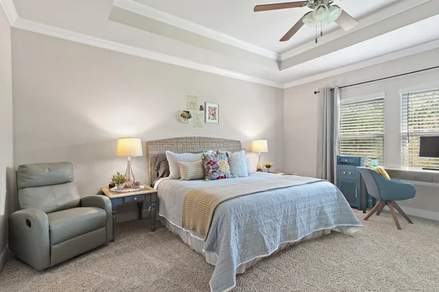 a bedroom with a bed a couch and a chandelier