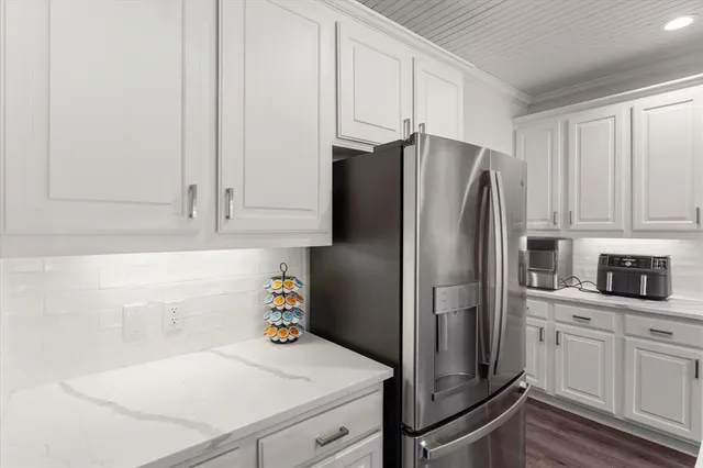 a kitchen with granite countertop white cabinets and stainless steel appliances