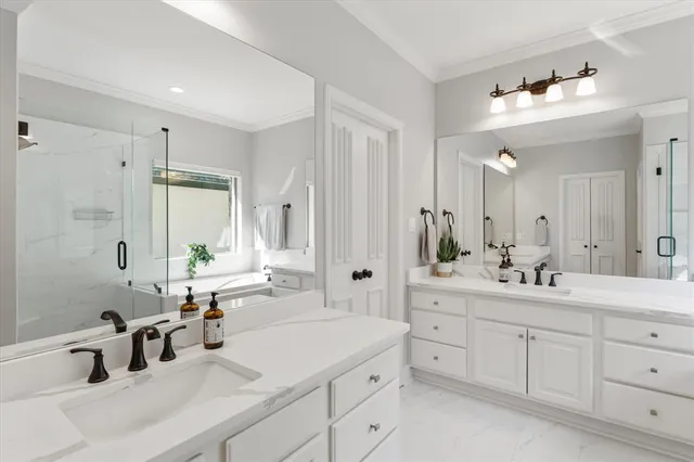 a bathroom with double vanity sinks a mirror a vanity and a shower