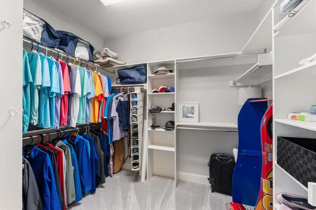 a view of walk in closet with clothes and shoes