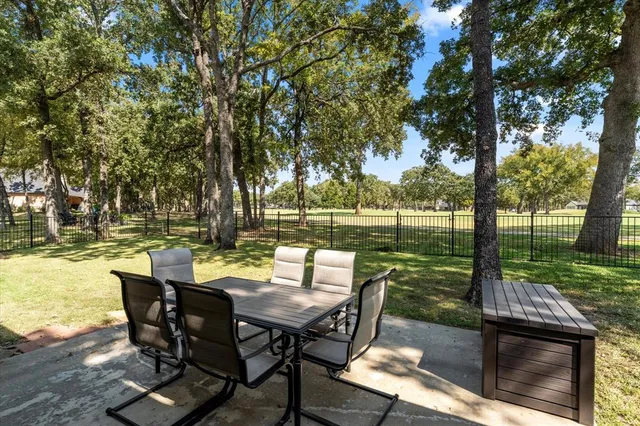 a view of a patio with table and chairs and a barbeque with wooden fence