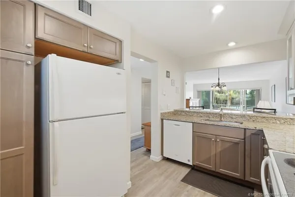 a kitchen with appliances a sink and a refrigerator