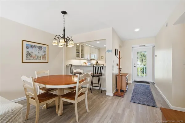 a dining room with furniture a chandelier and wooden floor