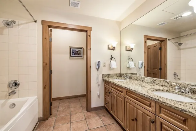 a spacious bathroom with a granite countertop tub sink and mirror