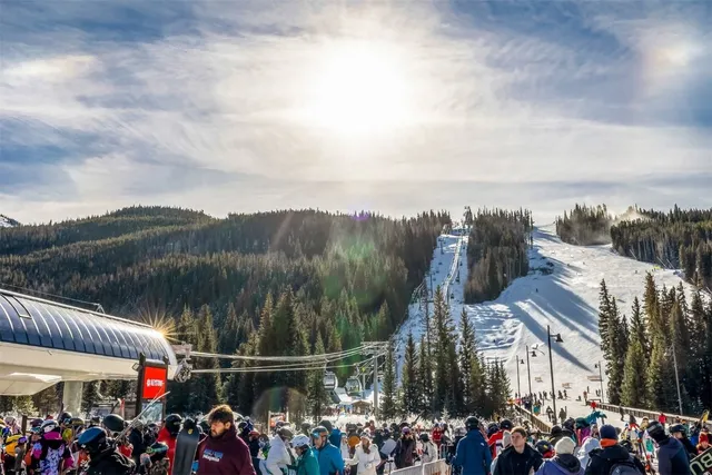 a view of a patio with couches chairs and a table and chairs with wooden floor and fence