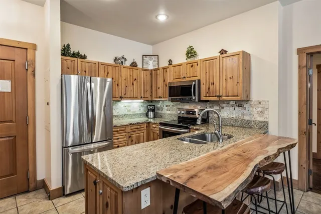 a kitchen with kitchen island a refrigerator stove microwave and cabinets