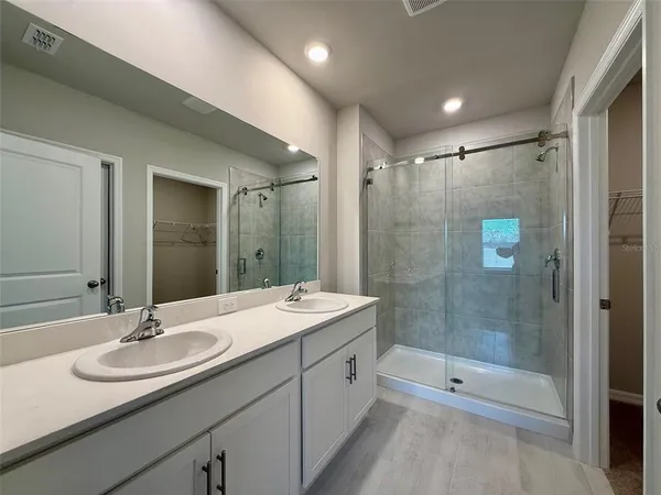 a bathroom with a shower sink double and mirror