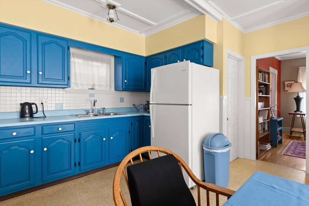 56 Washington Street Gloucester, MA 01930 - Photo 11 of 29 a kitchen with sink a refrigerator and wooden cabinets