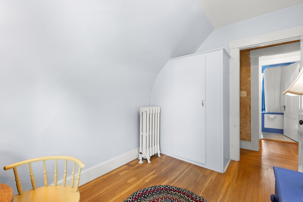 56 Washington Street Gloucester, MA 01930 - Photo 14 of 29 a bedroom with a bed and wooden floor