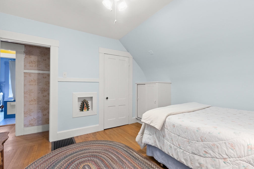 56 Washington Street Gloucester, MA 01930 - Photo 18 of 29 a bedroom with a bed and wooden floor