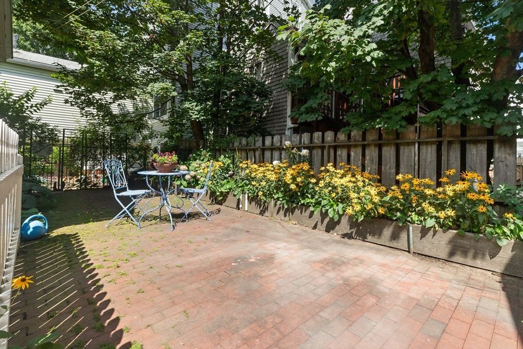 56 Washington Street Gloucester, MA 01930 - Photo 24 of 29 a garden with a bench and some trees