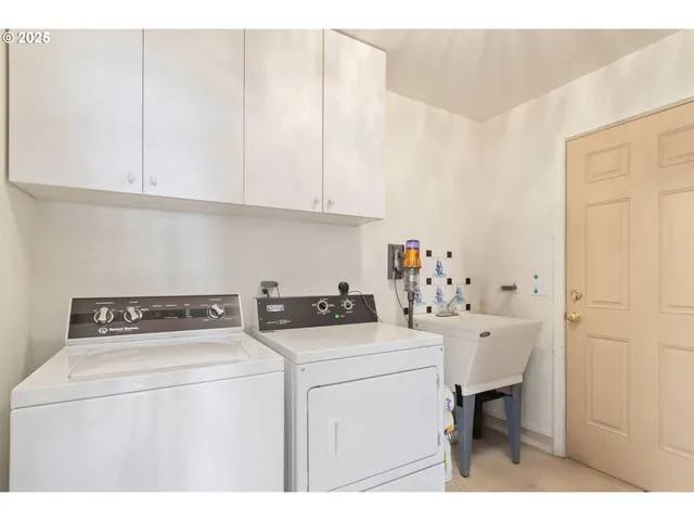 a utility room with dryer washer and a view of kitchen