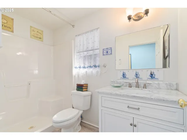 a bathroom with a granite countertop sink mirror vanity and toilet