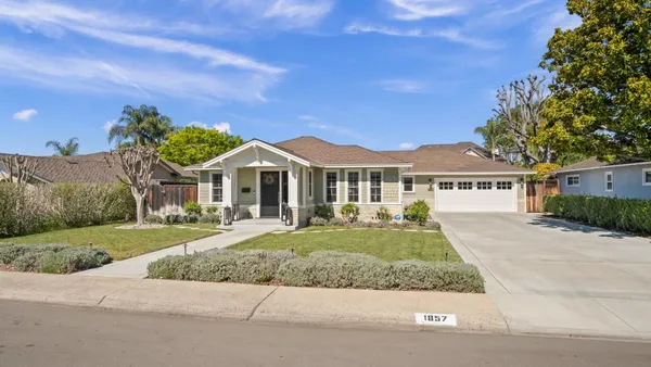 a front view of a house with a yard and trees