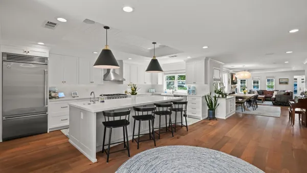a kitchen with stainless steel appliances granite countertop a lot of counter space dining table and chairs