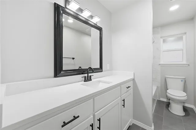 a bathroom with a sink a toilet and a mirror