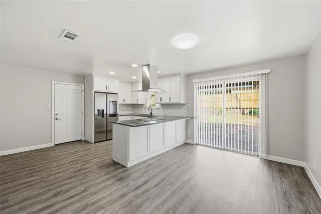 a large kitchen with a wooden floor and a large window