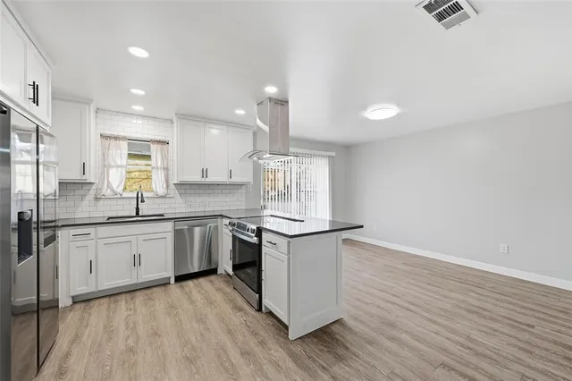 a kitchen with granite countertop a stove top oven sink and cabinets