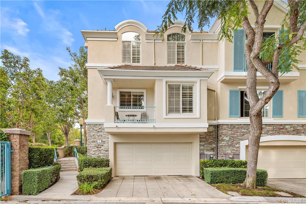 a view of a white house with large windows and a small yard