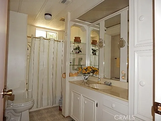 a bathroom with a double vanity sink toilet and shower