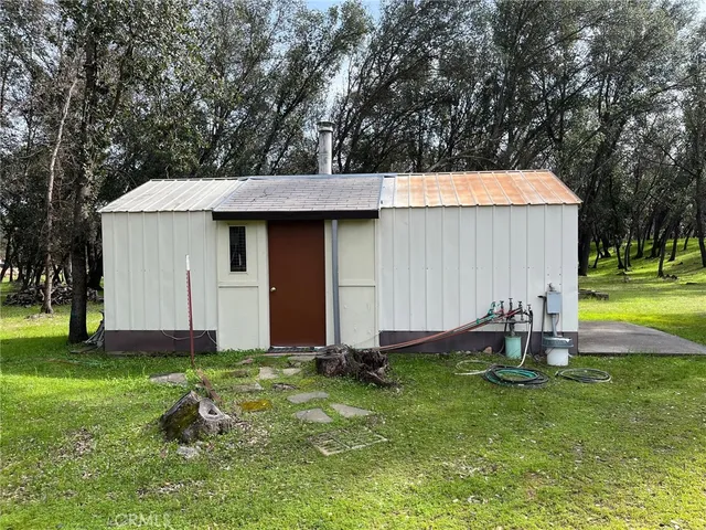 a backyard of a house with barbeque oven table and chairs