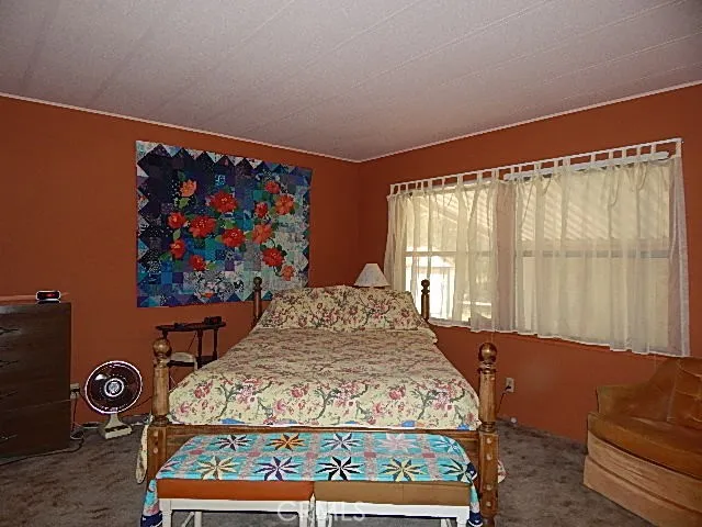 a bed sitting in a bedroom next to a window