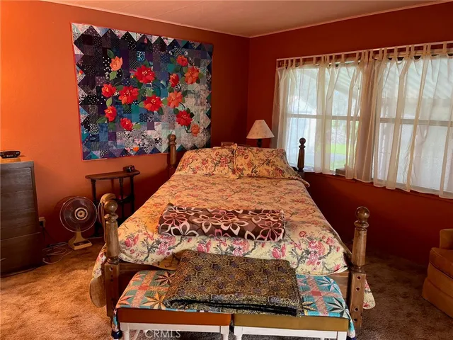 a bed sitting in a bedroom next to a window