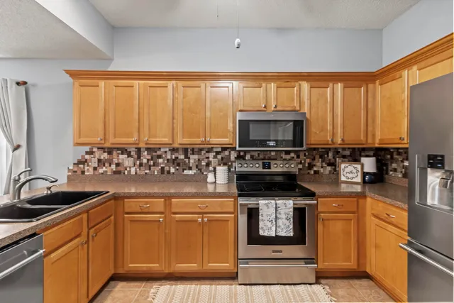 a kitchen with stainless steel appliances a stove sink and microwave