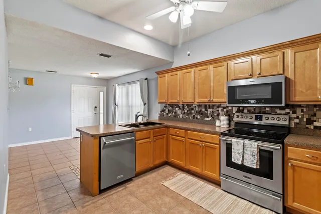 a kitchen with stainless steel appliances a stove sink microwave and cabinets