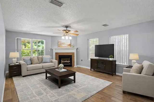 a living room with furniture a flat screen tv and a fireplace