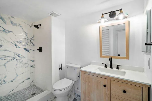 a bathroom with a double vanity sink a mirror and a bathtub