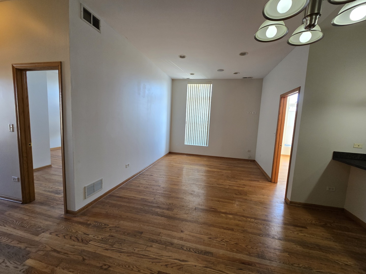 1700 West Cermak Road, Unit 2R Chicago, IL 60608 - Photo 3 of 10 an empty room with wooden floor and windows