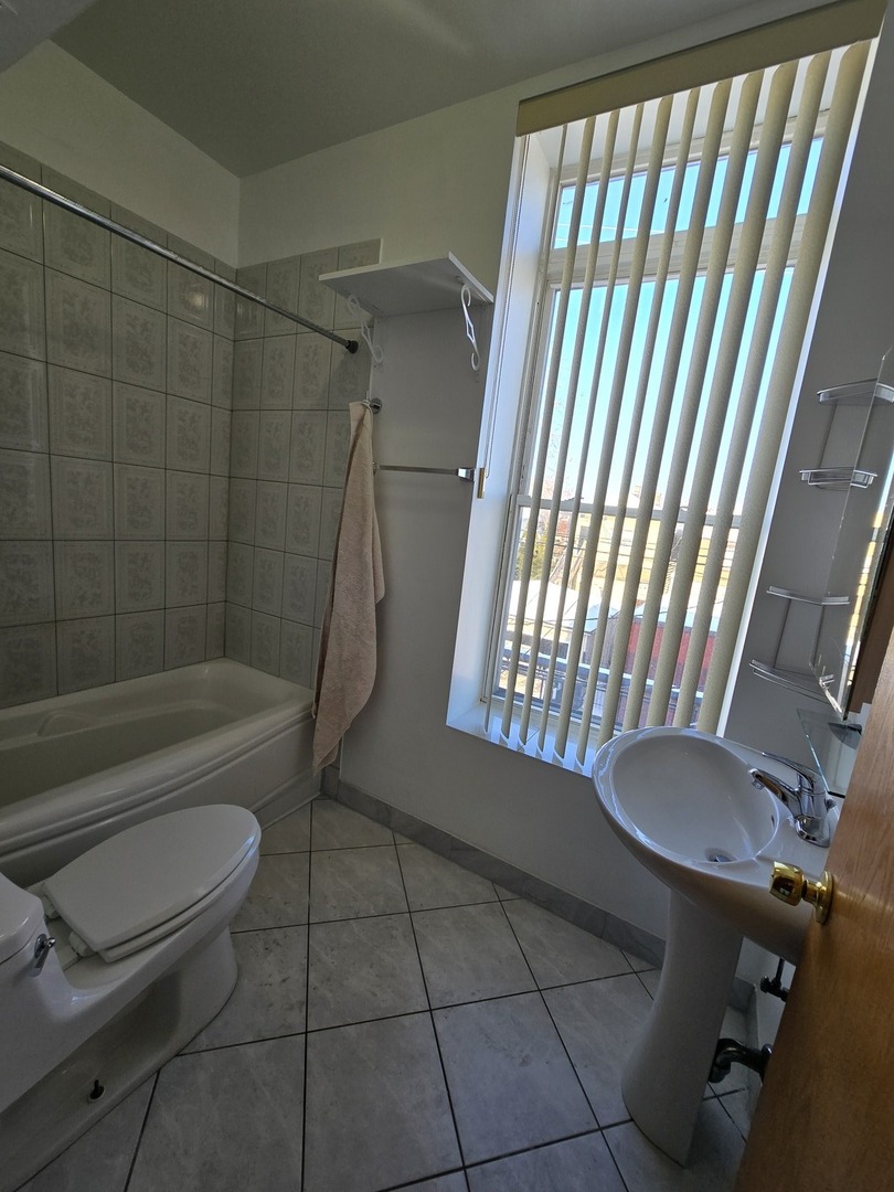 1700 West Cermak Road, Unit 2R Chicago, IL 60608 - Photo 6 of 10 a bathroom with a toilet and a bathtub