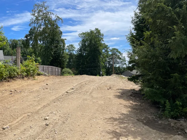 a view of wooden fence under a large tree
