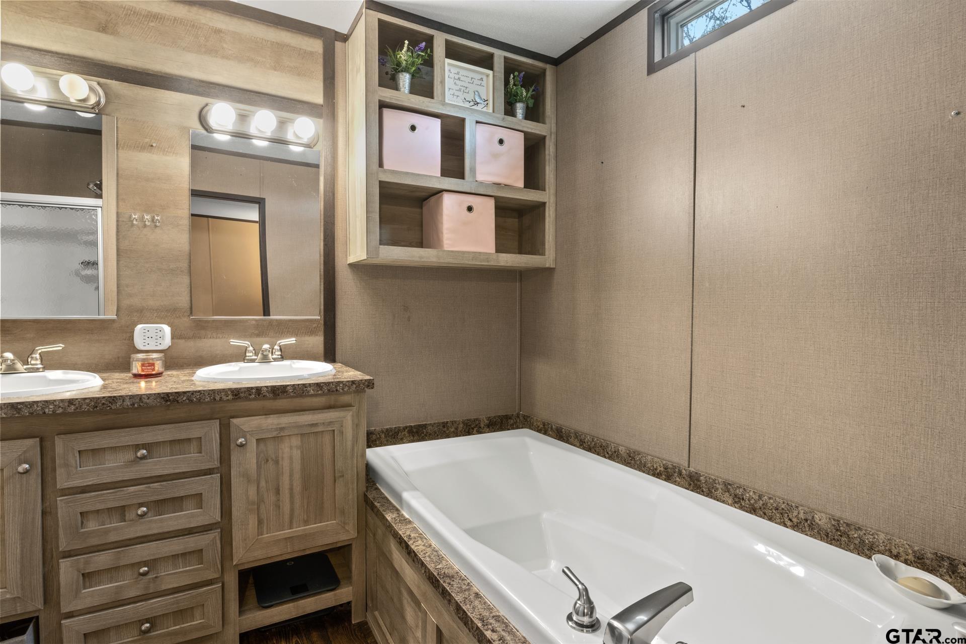 944 County Road 1240 Pittsburg, TX 75686 - Photo 12 of 33 a bathroom with a granite countertop sink and a bathtub