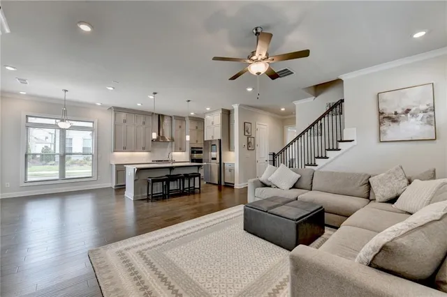 a kitchen with stainless steel appliances granite countertop a table chairs refrigerator and sink