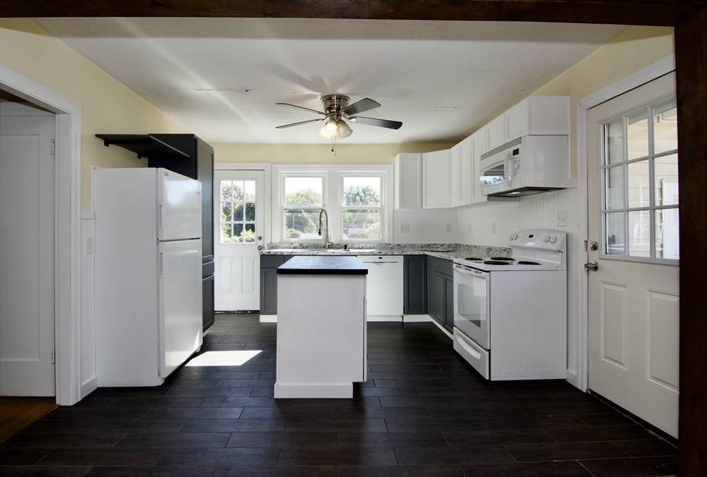 586 Granby Road South Hadley, MA 01075 - Photo 8 of 36 a kitchen with stainless steel appliances a refrigerator a sink dishwasher a stove and white cabinets with wooden floor