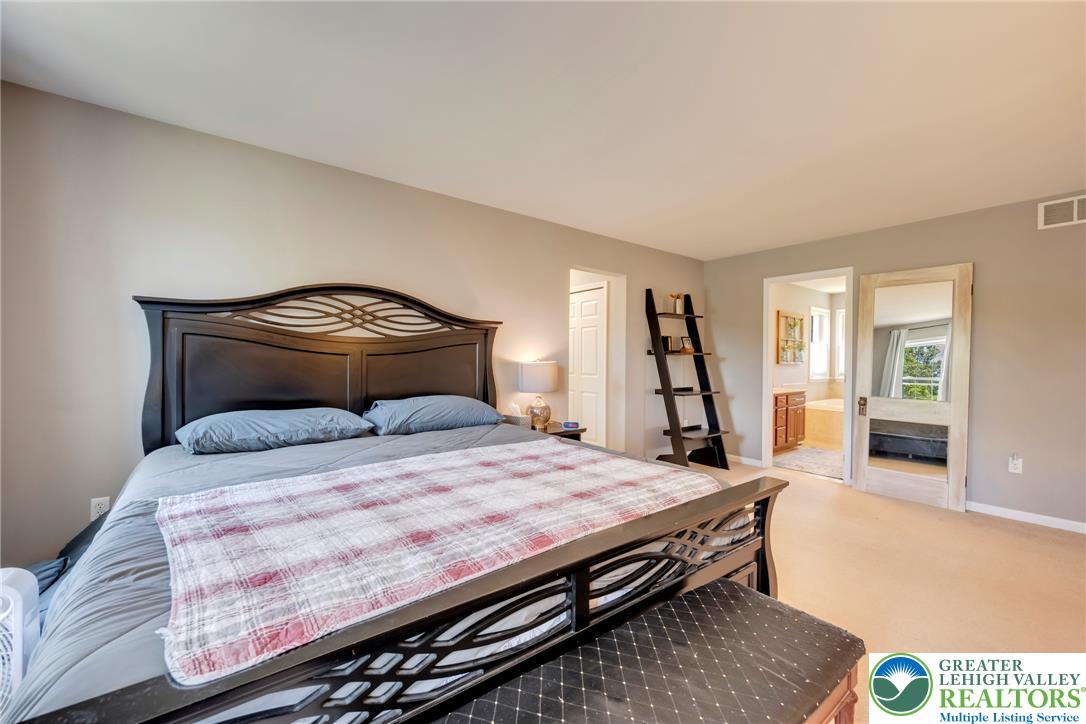 204 Bushkill Ridge Road Wind Gap, PA 18091 - Photo 26 of 48 A spacious primary bedroom features carpet flooring and convenient access to a private bathroom.